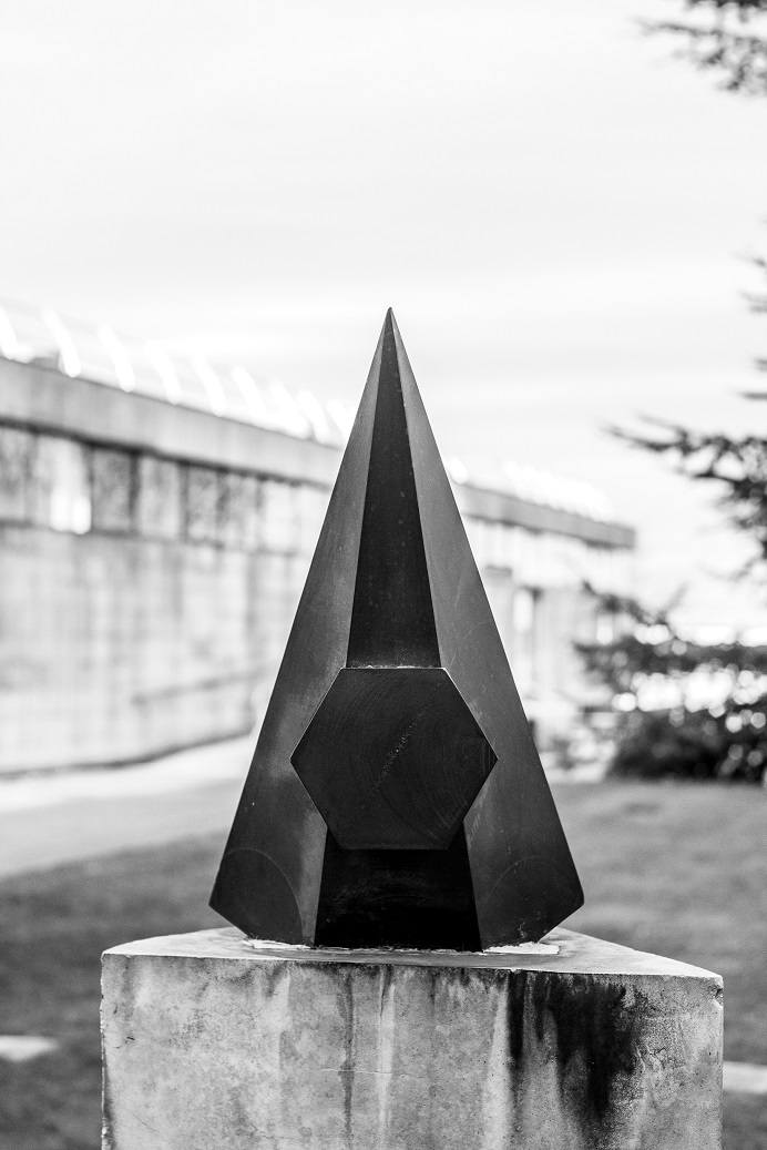 By photographing Michael Dan Archer’s Per Saeculi Quartum from a head-on angle, Cross has encouraged reflection on its triangular vertical forms, which don’t reveal themselves when first viewing the sculpture. 